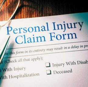 Personal injury claim form with pen and eyeglasses
