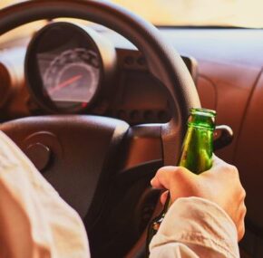 female drinking beer while driving car