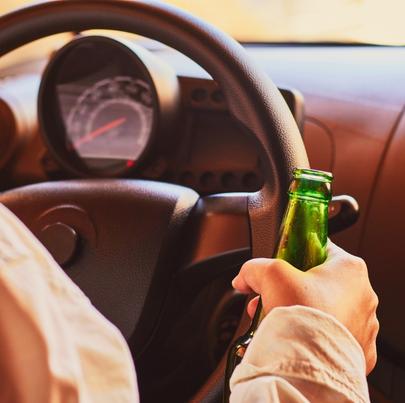 female drinking beer while driving car