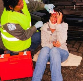 Female paramedic attending to woman car crash victim