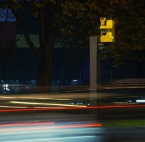 A photo of a speed camera and light trails of moving vehicles
