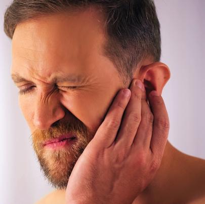 Man with hearing loss holding his ear