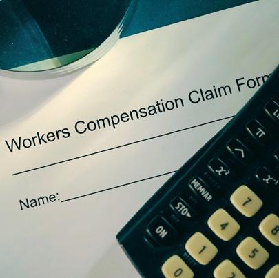Shot of workers compensation claim form with calculator