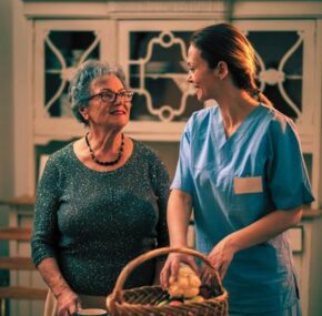 Nursing home caregiver giving senior woman food