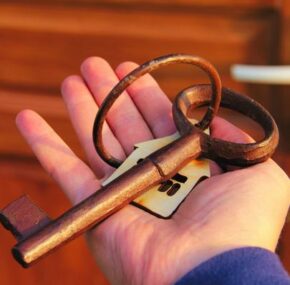 Large retro key with key fob at home in the hand of the property owner