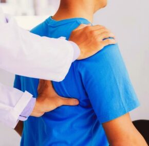 Doctor checking nurse's back strain