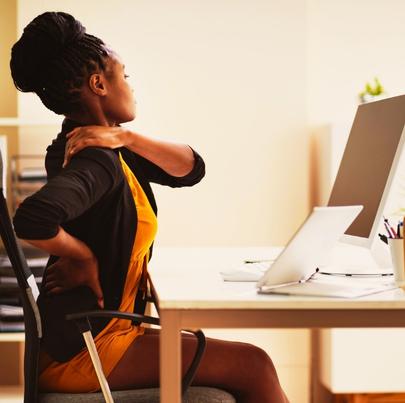 Woman having back pain from bad posture from using her computer from extended period