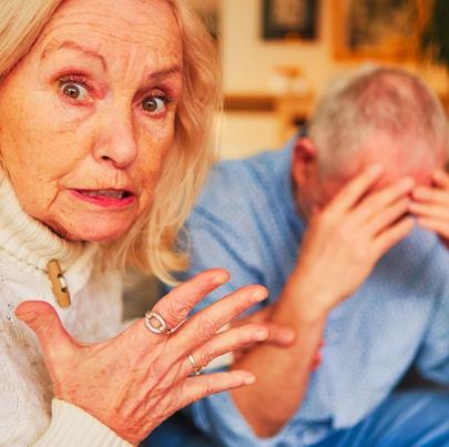 Angry senior woman verbally abusing senior man in nursing home