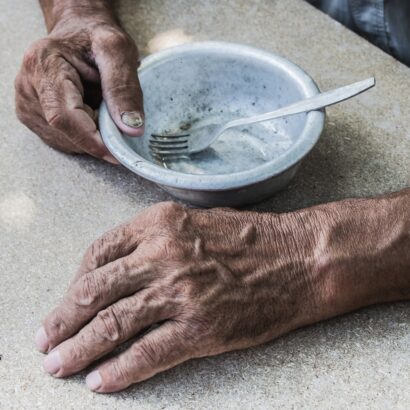 Hands of elderly with empty bowl