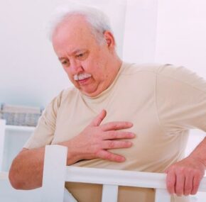 Obese senior man holding having chest pain in nursing home