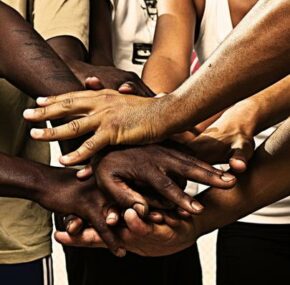 Group of mixed race people holding hands together forming a union for reform