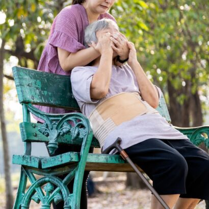 Asian caregiver hurting her senior patient by covering her mouth outside the nursing home