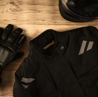 View of motorcycle accessories. Includes motorcycle helmet, riding gloves and riding jacket.
