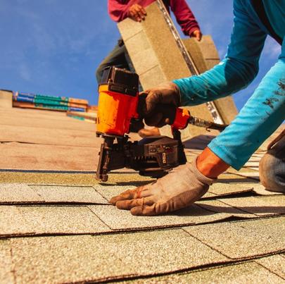 Roofer Installing Roof Shingles with Nail Gun