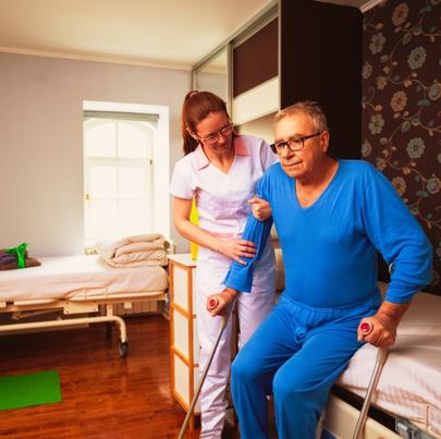 Immobile senior man helped by nurse at a nursing home