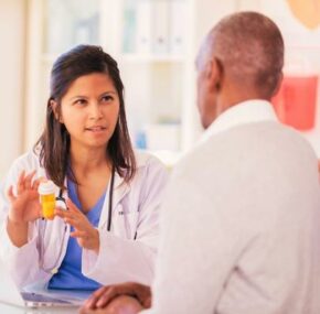 Concerned female doctor holding a prescription bottle of medicine while discussing the side effects to her patient