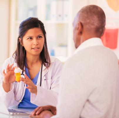 Concerned female doctor holding a prescription bottle of medicine while discussing the side effects to her patient