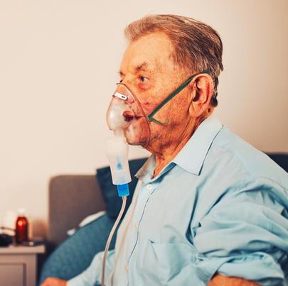 Elderly man at a nursing home using an inhaler due to lung disease
