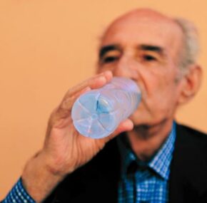 Dehydrated elderly man, drink water in a bottle