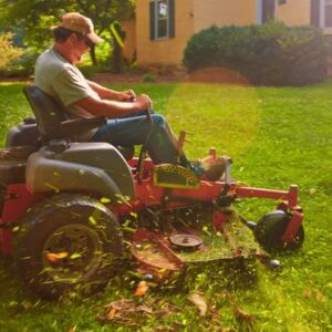 Landscaper cutting grass riding his lawn mower