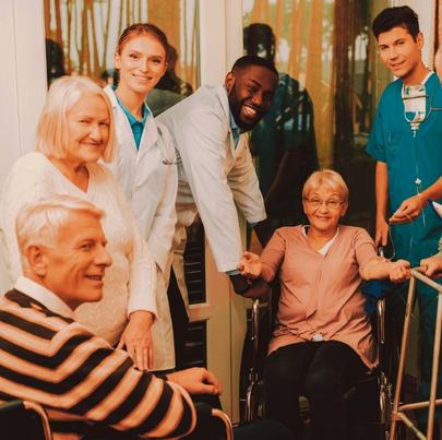 Group of nursing home staff smiling together with their patients