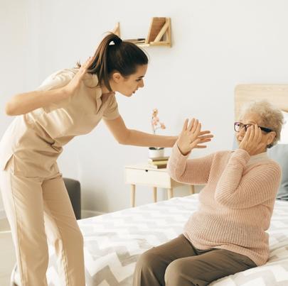 Caregiver mistreating senior woman in nursing home