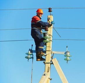 Power Electrician Lineman at Work on Pole