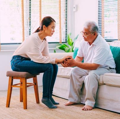 Caregiver consoling senior male in nursing home