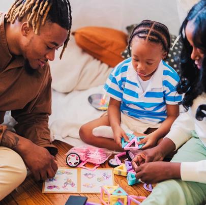 Parents and their child playing with magnetic blocks