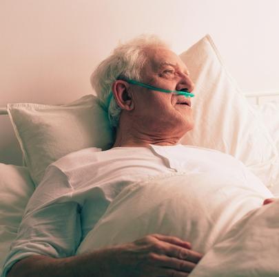 Sick dying elderly man in hospital bed looking out the window