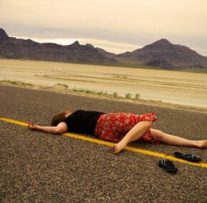 A young woman lies on the ground as a result of a hit and run accident