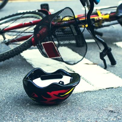 Helmet and bike lying on the road, on the pedestrian crossing after an accident