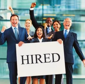 Group of happy lawyers or business people holding a hired sign