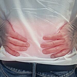 Man's hands on his back with red spot as suffering on backache.