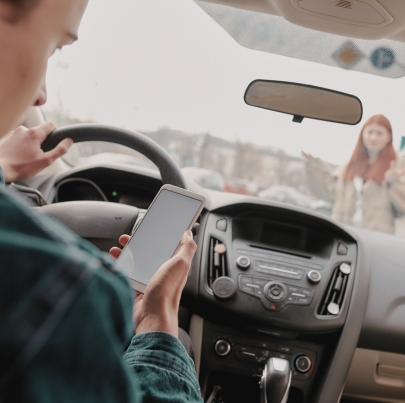 Distracted young male driver looking at the screen of his mobile phone while running over a pedestrian. Concept of what to do if you get hit by a car as a pedestrian