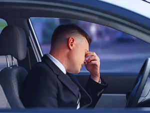 Exhausted male in formal suit sitting on driver seat, stressful life, overwork. Can You Sue an Uninsured Driver