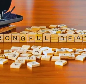 Wrongful death word or concept represented by wooden letter tiles on a wooden table.