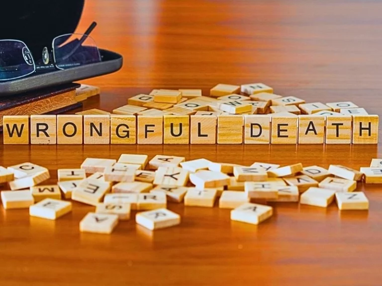 Wrongful death word or concept represented by wooden letter tiles on a wooden table.