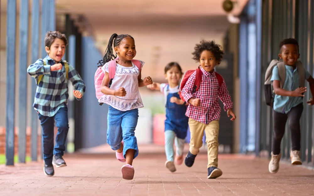 Children running down a school hallway as they return back to school.