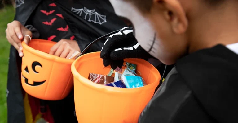 Children looking at their halloween bucks full of candy.